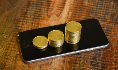 Stack of Golden Coins on Mobile Screen - Earning concept
