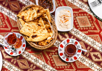 Flat view from above on a table in a traditional Turkish restaurant with delicious tea and bread with sauce