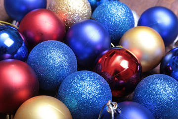 Red, blue and gold christmas balls on a wooden background