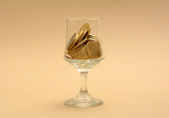 Glass Half filled with Golden Coins - Finance Concept
