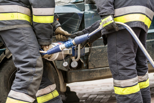 Firefighters Working On An Auto Vehicle Extrication With A Hydraulic Power Rescue Tool