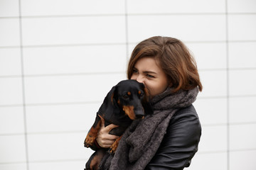 People, animals, breeding, friendship, loyalty, devotion and happiness concept. Close up shot of fashionable young Caucasian female hugging tight her pet dog, feeling strong affection and love