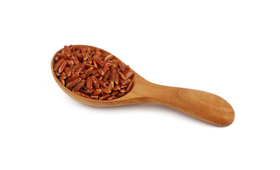 Red brown raw rice in wooden scoop on white