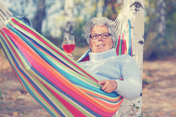 sonniger Tag im Herbst - Seniorin trinkt Wein
