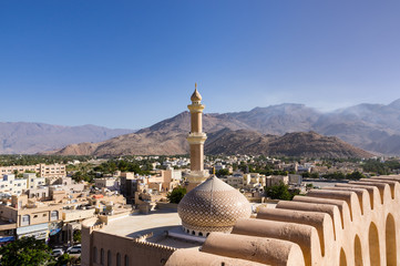 The Grand mosque and minaret in Nizwa viewed from the Nizwa fortress in Oman. - obrazy, fototapety, plakaty