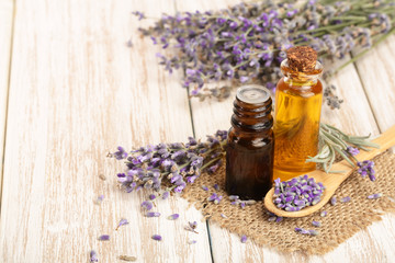 Fototapeta na wymiar Herbal oil and lavender flowers on wooden background