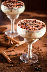 tiramisu in a glass decorated with coffee beans on a dark background