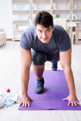 Young man exercising at home in sports and healthy lifestyle con