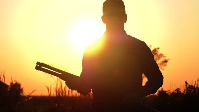 man one hand pumps his shotgun sunset 4k