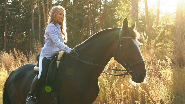 beautiful girl riding on a horse hugging her and stroking