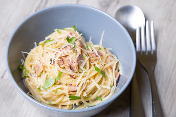 Pasta carbonara with bacon, cheese and parsley. Traditional Italian dish. Close-up, selective focus.