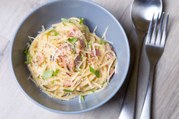 Pasta carbonara with bacon, cheese and parsley. Traditional Italian dish. Close-up, selective focus.