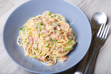 Pasta carbonara with bacon, cheese and parsley. Traditional Italian dish. Close-up, selective focus.