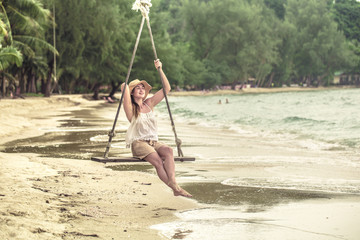 girl on the swing on the beach of Thailand