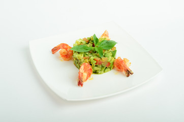 Salad with shrimps, avocado, cherry tomatoes decorated basil on a plate isolated on white background