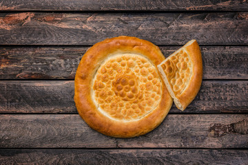 Traditional tandyr bread of Central Asia on a wooden background. Top view