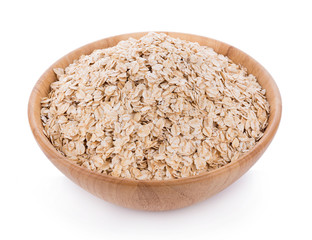 Oat flakes pile in wooden bowl on white