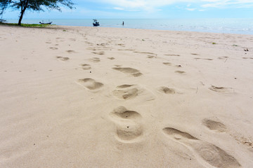 Footprint on the beach with blue sky and cloud for abstract background.
