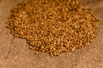 Pile of the raw buckwheat on sackcloth