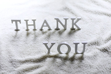 Wooden wthite letter Thank you on the crumpled carpet