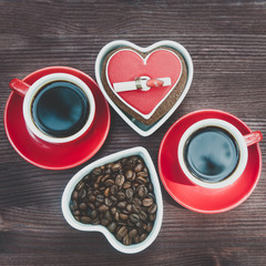 Background on a theme of coffee with place for text. Two cups of coffee, espresso, coffee beans, wooden table.