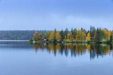 Fototapeta na wymiar Forests and lake view in autumn. Fall colors - ruska time in Ruka. Finland, Lapland, Nordic countries in Europe