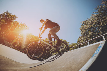 Bmx rider performing tricks at skatepark.