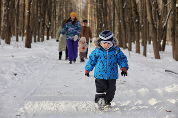 Kid running in winter park and have fun with family