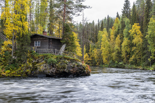 Cliff, stone wall, forest, waterfall and wild river view in autumn. Fall colors - ruska time in Myllykoski. One part of Karhunkierros Trail. Oulanka National Park in north Finland. Lapland, Europe