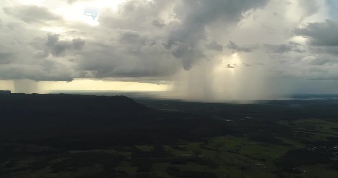 4K Aerial view,Panning shot of Rainstorm and thunderstorm clounds over the field with mountain,THAILAND