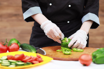 The cook cuts fresh farm vegetables