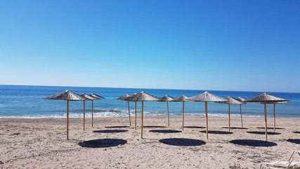 Fototapeta premium sea umbrellas shadows autum in Preveza Greece