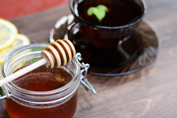 Fresh honey with a cup of black tea