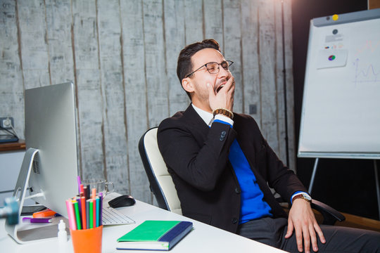 Businessman yawning at office boring job concept. Bored worker