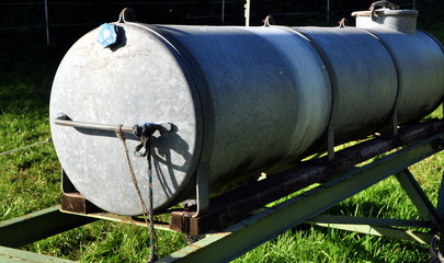 Viehtränke mit Wasserfass aus Zink auf einer Weide 