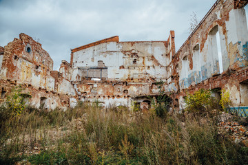 Ruined and overgrown by plants red brick industrial building. Abandoned and destroyed sugar factory in Novopokrovka, Tambov region