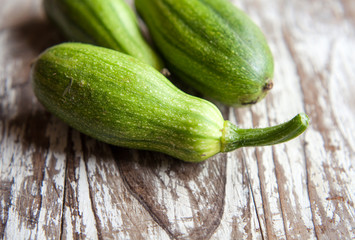 Small green pumpkins on rustic wooden background with copy space