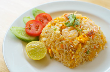 Shrimp fried rice with tomatoes, cucumbers and lemon .
