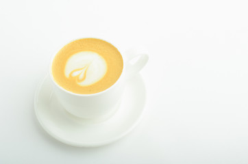 A cup of cappuccino coffee with heart shaped milk foam isolated on white background