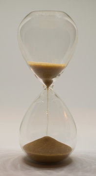 timeglas with sand running out on white background