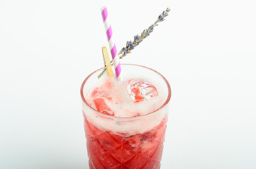 Red berry lemonade with ice decorated lavender in glass isolated on white background