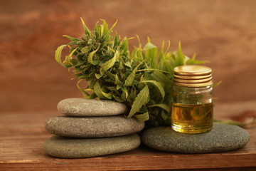 alternative medicine green leaves of medicinal cannabis with extract oil on a wooden table