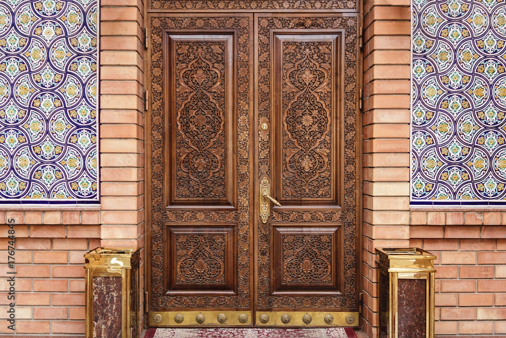 Wall mural facade of an old building door with traditional uzbek carved floral wooden ornament wooden backgroun