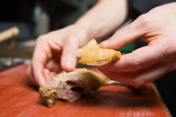 A free range, succulent cooked duck leg fillet, being cut open to reveal the freshly cooked tender duck meat and golden tasty duck skin.