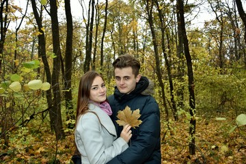 young loving couple in the autumn forest