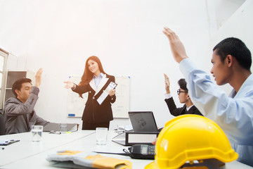 teamwork businessman and engineer in cafe outdoor with laptop computer, blueprint, yellow helmet. Selective focus. Executives stand around meeting table with all hands placed on the table top.