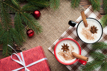 eggnog cocktail in  mug arranged with christmas decoration on wooden table