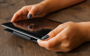 woman's hand pointing , touching and using tablet on a wooden background.