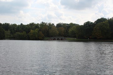 Fototapeta na wymiar The lake in the park with the bridge in the background.