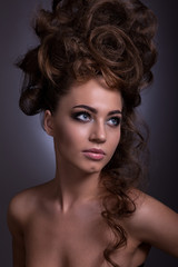 Fototapeta premium Portrait of a beautiful girl with a creative high hairstyle and makeup.